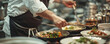 © Coosh448 - A chef preparing a meal in a busy kitchen, their hands moving with precision and their passion for food evident.