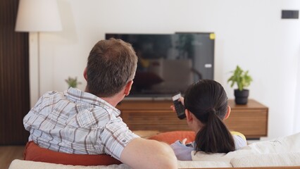 Grandfather and granddaughter together watch interesting entertainment media on TV. Old senior use technology communicate with young generation cross generation gap strengthen family bond. Divergence.