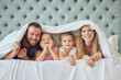 © peopleimages.com - Family, portrait and happy in bedroom on weekend with relax, comfort or safety in bonding or together. People, parents and children with rest, blanket in morning in home for love, affection or peace
