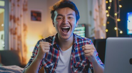 Wall Mural - A young man of Kazakh appearance using a laptop won an online lottery and is happy about it