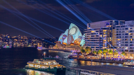 Wall Mural - Colourful Light show at night on Sydney Harbour NSW Australia. The bridge illuminated with lasers and neon coloured lights 