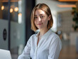 © Lull - Confident young professional woman in office setting. Young female entrepreneur with a determined expression, embodying ambition and success in a modern workplace.