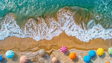 Wall Mural - A top view of colorful umbrellas scattered along the beach, with waves crashing onto golden sand and a blue sea in the background.