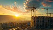 © Lakkhana - A construction site with cranes and a sunset in the background