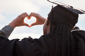Wall Mural - Black girl, sign and heart hands with blue sky on graduation for education love, achievement and celebration for degree. Student back, gesture and gratitude for accomplishment, graduate and outdoor.