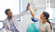 © Lumeez23/peopleimages.com - Dentist, patient and happy with high five for celebration or success of teeth whitening, oral and dental care. Male doctor, woman and together for well done or good job, support and consultation.