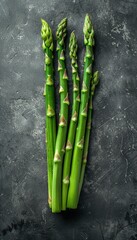 Sticker - A bunch of green asparagus on a dark grey backdrop. Ideal for culinary content, diet promotions, or organic food marketing.