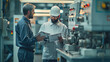 © visoot - Two engineers with clipboards holding document papers, discussing a work plan on a CNC machine at a factory. In the background is an electrical panel, industrial machinery concept. Generative AI.