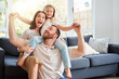 © ChasingMagic/peopleimages.com - Excited, family and portrait on shoulder by sofa for weekend fun, happiness and bonding together. Playful, dad and mom with daughter in living room for love, support and care at home on fathers day