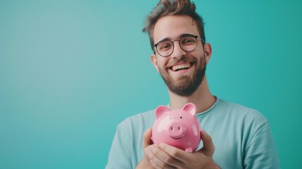 Wall Mural - Happy male holding a pink piggy bank