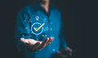 © Supatman - Businessman holding a digital icon of a checkmark with quality assurance and certification symbols, standard compliance and guarantee. quality control, automation process, Standardization management,