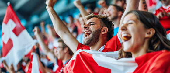 Switzerland football soccer fans in a stadium supporting the national team wearing red shirt, supporting , cheering and rising Switzerland national flag in european football league