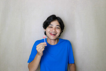 portrait of a very attractive random handsome Asian Indonesian man on a white isolated background wearing blue clothes