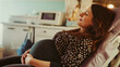 © Frank Gärtner - Pregnant woman with eyes closed, lying on a medical bed, holding her belly, during a medical appointment in a hospital room