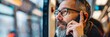 © Natalia - An elderly man with glasses talking on a cell phone while looking out a train's window. AI.