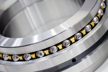 Aufkleber - A silver and gold bearing. The bearing is made of metal and has a shiny surface, Industrial concept background