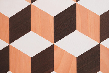 Aufkleber - A pattern of brown and white squares is on a wooden surface. The squares are arranged in a way that creates a sense of depth and dimension. The pattern is visually interesting