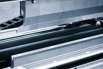 Aufkleber - Industrial machine for stamping and bending sheet metal. The car is silver and black. The metal is cut into a curved shape.