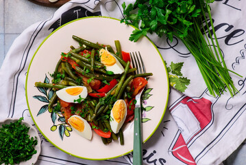 Poster - Warm vegetable salad with green beans and boiled eggs on a plate with an ornament..top veiw.selective focus