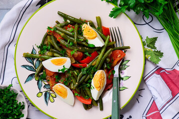 Canvas Print - Warm vegetable salad with green beans and boiled eggs on a plate with an ornament..top veiw.selective focus