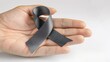 © AkuAku - Boosting awareness for brain cancer is symbolized by a grey ribbon adorning a helping hand isolated with a clipping path signifying support for conditions like allergies Alpha 1 Antitrypsin