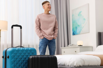 Canvas Print - Guest exploring stylish hotel room, focus on suitcases