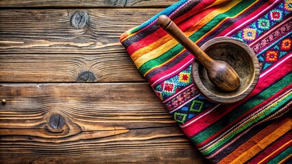 Poster - Vibrant traditional fabric adds pop of color to rustic wooden table setting featuring wooden spoon, small molcajete, and empty space for text.