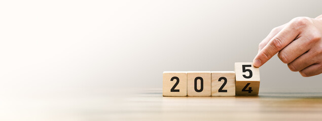 Transitioning from 2024 to 2025 with wooden blocks symbolizing target business for the upcoming year. This represents planning, investment, and innovation as ideas move from the end of 2024 new year