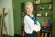 © Anatoliy Karlyuk - Portrait of stylish elderly female interior designer in business clothes and blue silk scarf standing in living-room of her design project with crossed hands, looking at camera with confidence