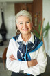 © Anatoliy Karlyuk - Portrait of confident happy successful senior businesswoman in elegant white blouse and silk scarf around neck standing with crossed hands and cheerful smile motivating you to run your own business