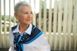 © Anatoliy Karlyuk - Outdoor portrait of elegant aged business lady looking aside on copy space for your advertising content standing against fence of office building. Successful working seniors concept