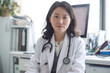 © Larisa - Professional Asian female doctor in clinic with stethoscope.