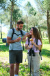 © Ladanifer - A man and a woman are smiling and holding apples. They are in a park hiking and seem to be enjoying each other's company