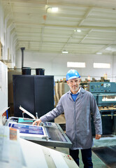 Canvas Print - Man, portrait and happy in factory for printing by machine, maintenance and production in workplace. Mature person, smile and helmet in industrial warehouse for design, brochure and press for paper