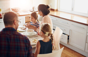 Canvas Print - Family, food and parents with children at table for breakfast, eating and bonding together in kitchen. Morning, happy woman and man with young kids for healthy meal, nutrition and hunger in home