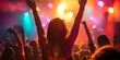 © Armin - Vibrant image of a crowd enjoying a live concert with colorful stage lighting and raised hands