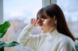 © Valerii Honcharuk - Middle aged woman experiencing headache migraine, at home near window