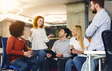 Aufkleber - Several individuals are seated at a table engaged in conversation. They appear to be actively listening and participating in the discussion, gesturing and making eye contact