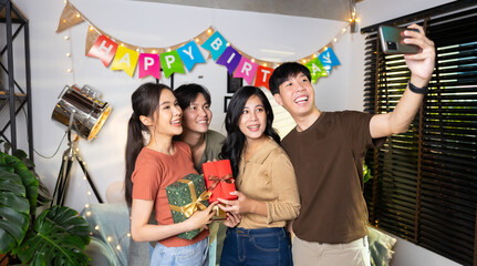 Selfie photo. Happy smile diverse friends enjoying time together and making selfie photo by mobile phone at home party. Group of asian people friends in birthday party at home