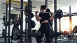 © Thanadon88 - A man is lifting weights in the gym. The scene is focused and focused. The man squats and lifts a barbell, indicating that he is working hard to build his strength and fitness.