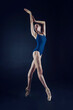 © Alex - ballerina on a dark background stands on pointe shoes demonstrating ballet movements and eversion of the foot