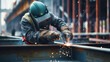 © Natalia - Close-up of a welder in protective gear performing welding work on a construction site with sparks flying.