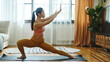 © Natalia - Woman practicing yoga in a living room, performing a stretch on a yoga mat. She is wearing activewear and the room is filled with natural light.