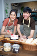 © NVB Stocker - Homemade, happy relaxing and wellness at home. Young asian man and woman preparing birthday cake for friends
