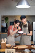 © NVB Stocker - Homemade, happy relaxing and wellness at home. Young asian man and woman preparing birthday cake for friends