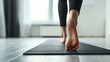 © Natalia - Close-up of a person's bare feet in yoga pose on a mat at home, focusing on movement and balance.