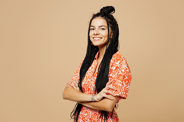 Wall Mural - Side profile view young smiling cheerful Latin woman she wears orange casual clothes hold hands hold hands crossed folded isolated on plain pastel beige background studio portrait. Lifestyle concept.