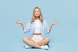 © ViDi Studio - Full body young woman wears white top shirt casual clothes sits hold spreading hands in yoga om aum gesture relax meditate try to calm down isolated on plain light blue background. Lifestyle concept.