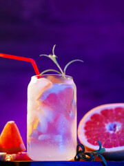 Wall Mural - refreshing chilled summer lemonade with grapefruit. stylish glass, purple background