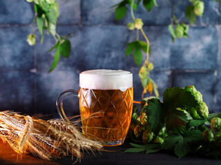 Wall Mural - Beer mug on the table with green hops